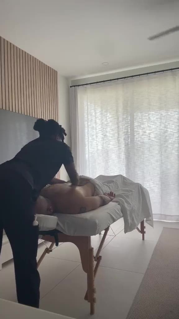 A TUTCH therapist giving an in-room treatment, booked in three easy steps in Barbados