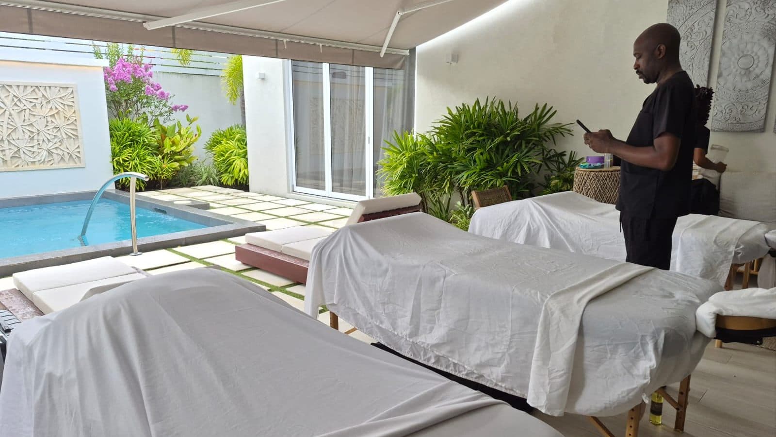Two massage tables beside a villa plunge pool, set up for a group spa day in Barbados